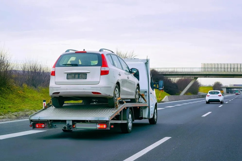 Recovery truck transporting a car on a UK motorway